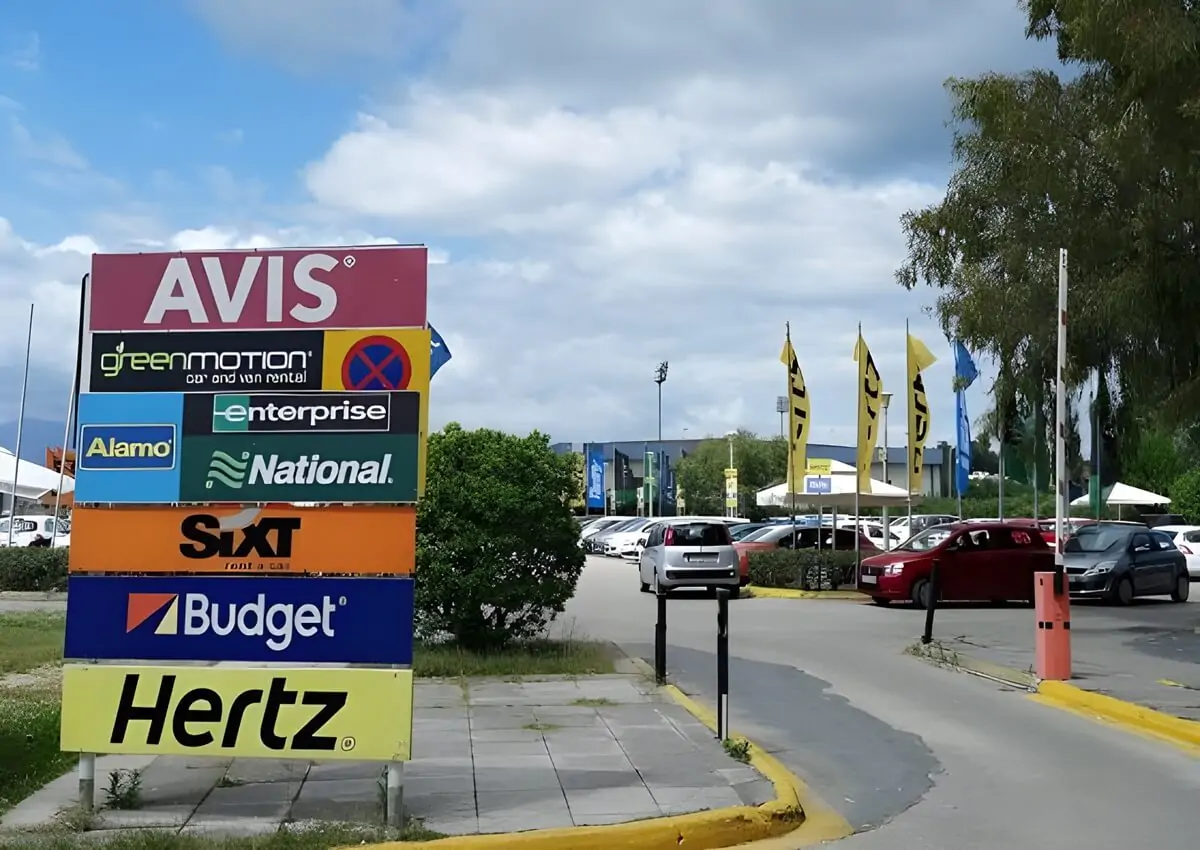 Reklamy firm wynajmujących samochody na lotnisku Korfu